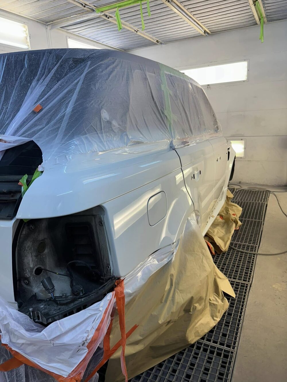 A car masked up in the spray booth during bodywork repairs at EE Motors
